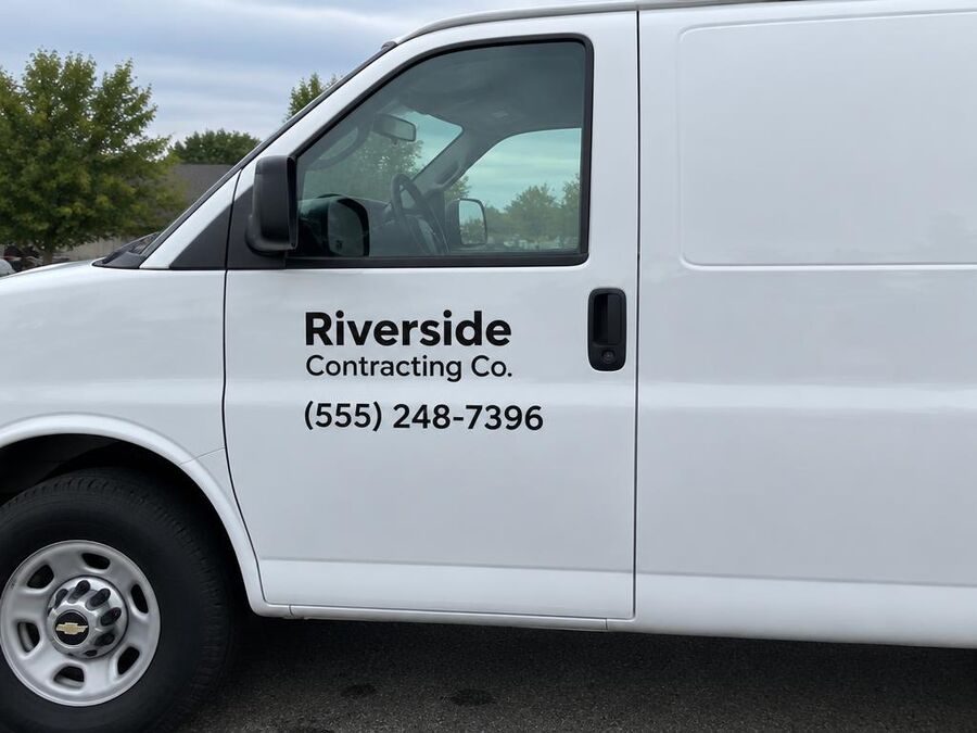 White van door with vinyl company name and phone number lettering